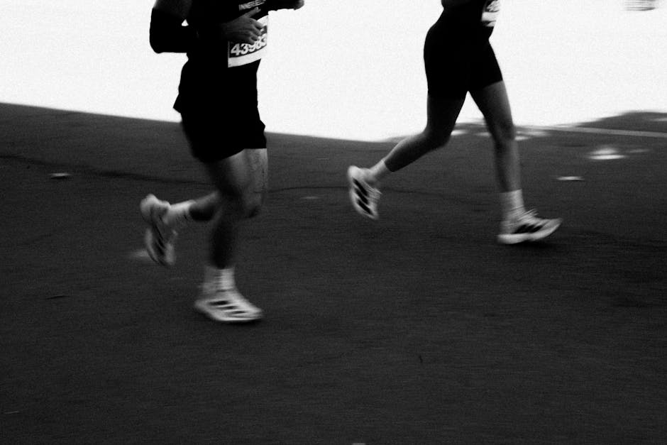 A pair of runners in colorful athletic gear stride along a paved path, their dynamic motion capturing the essence of marathon pacing strategy for the article 